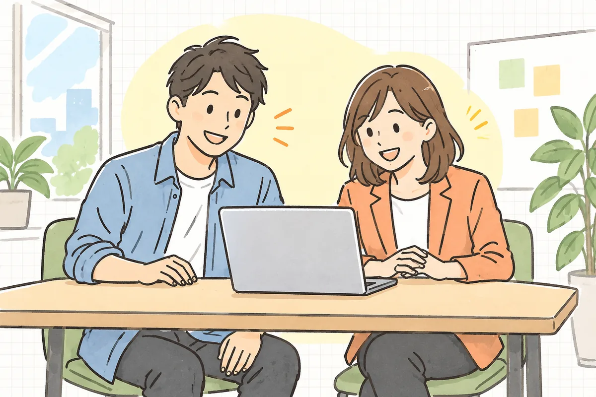 開発者と営業の同僚が並んで一つのノートPCの画面を見ながら、笑顔で話し合っている明るいオフィスの様子